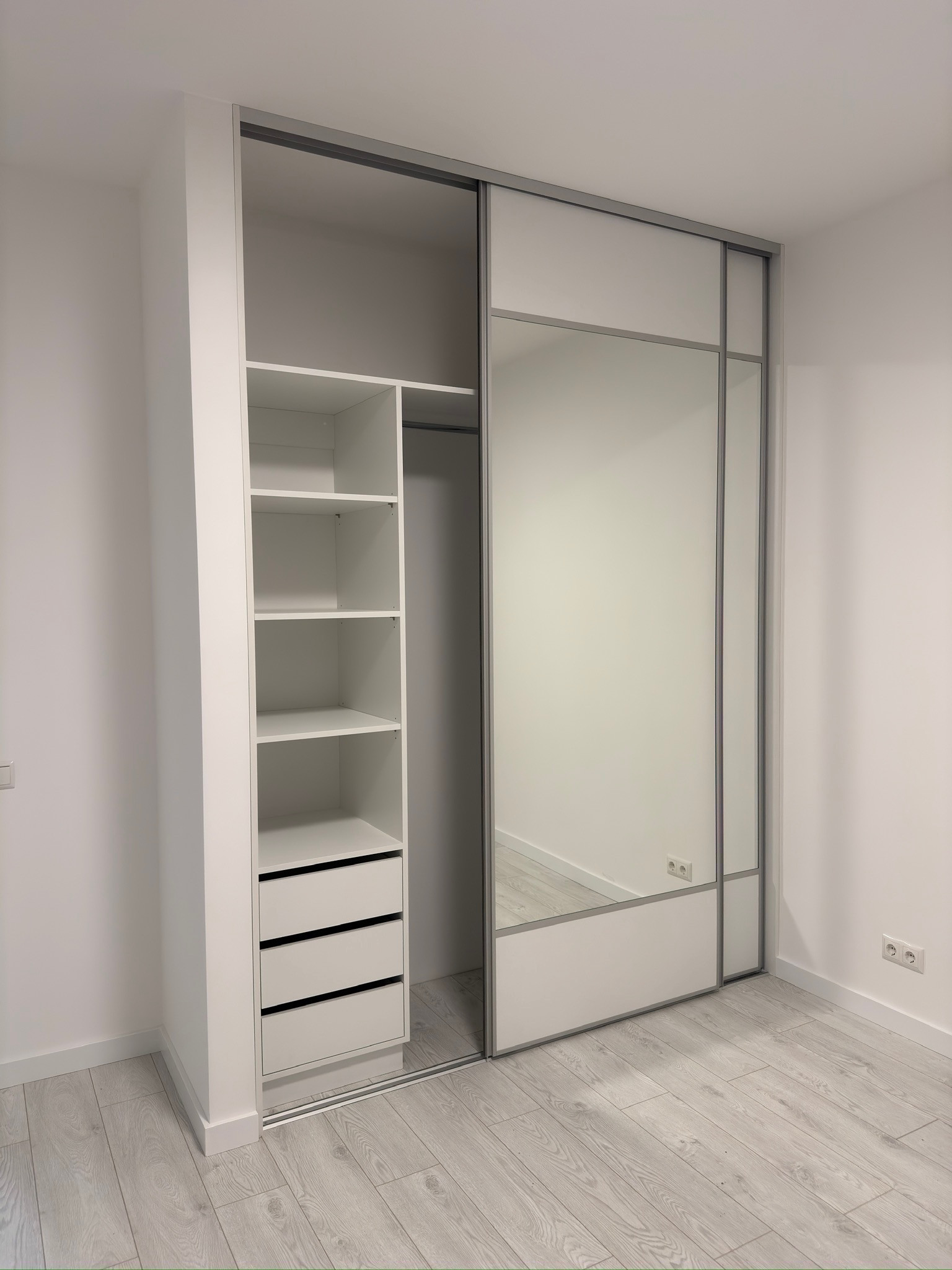 Built-in wardrobe with mirrored doors and shelving