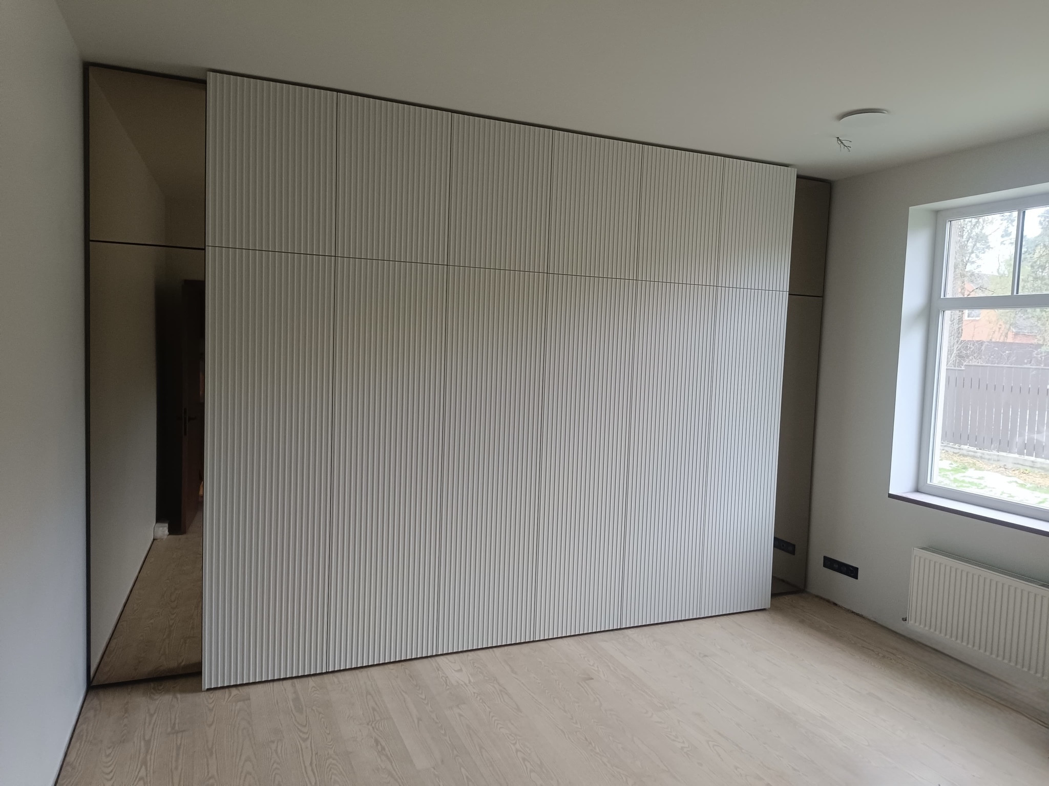 Walk-in wardrobe with fluted fronts and lighting