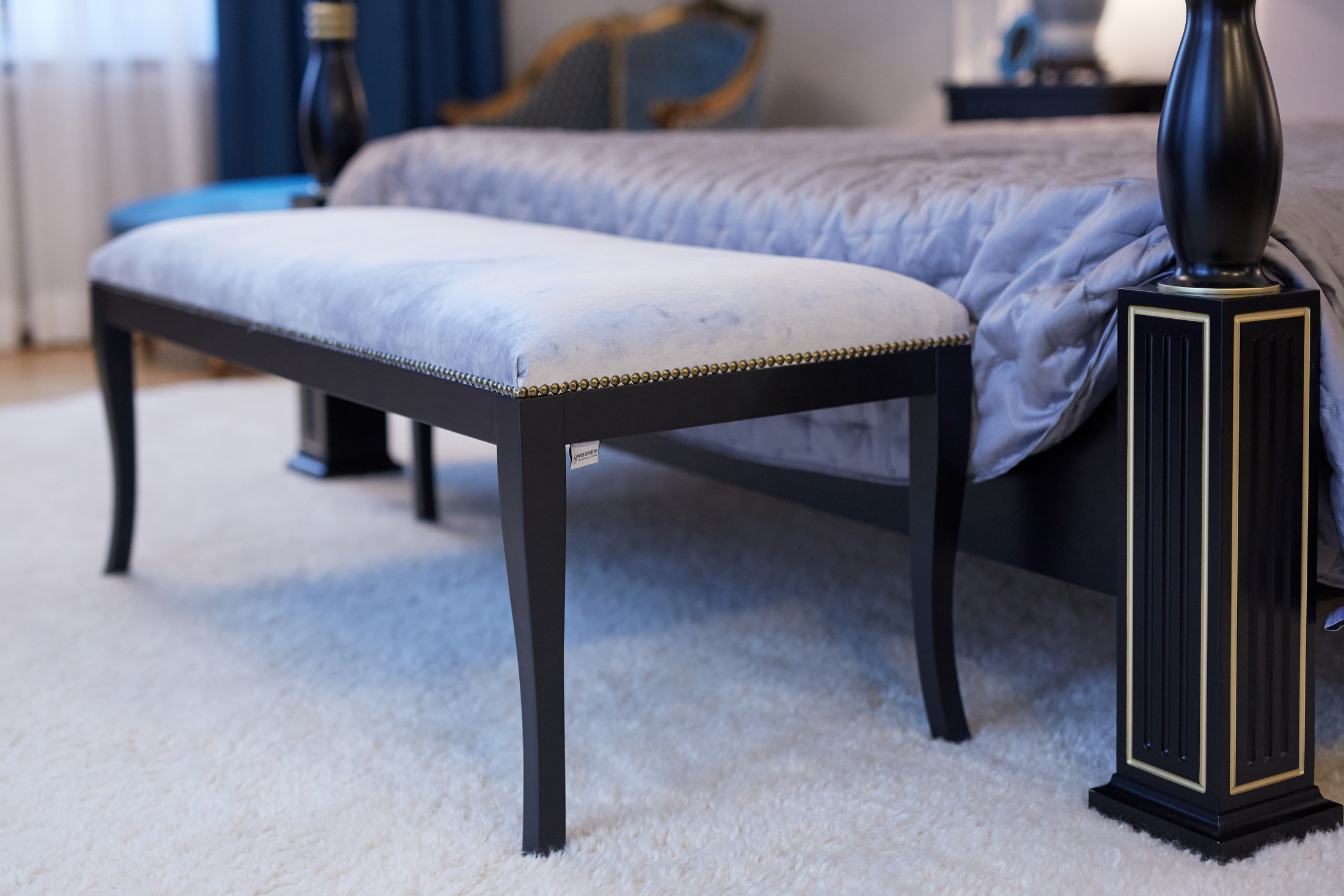 Upholstered bench beside a bed