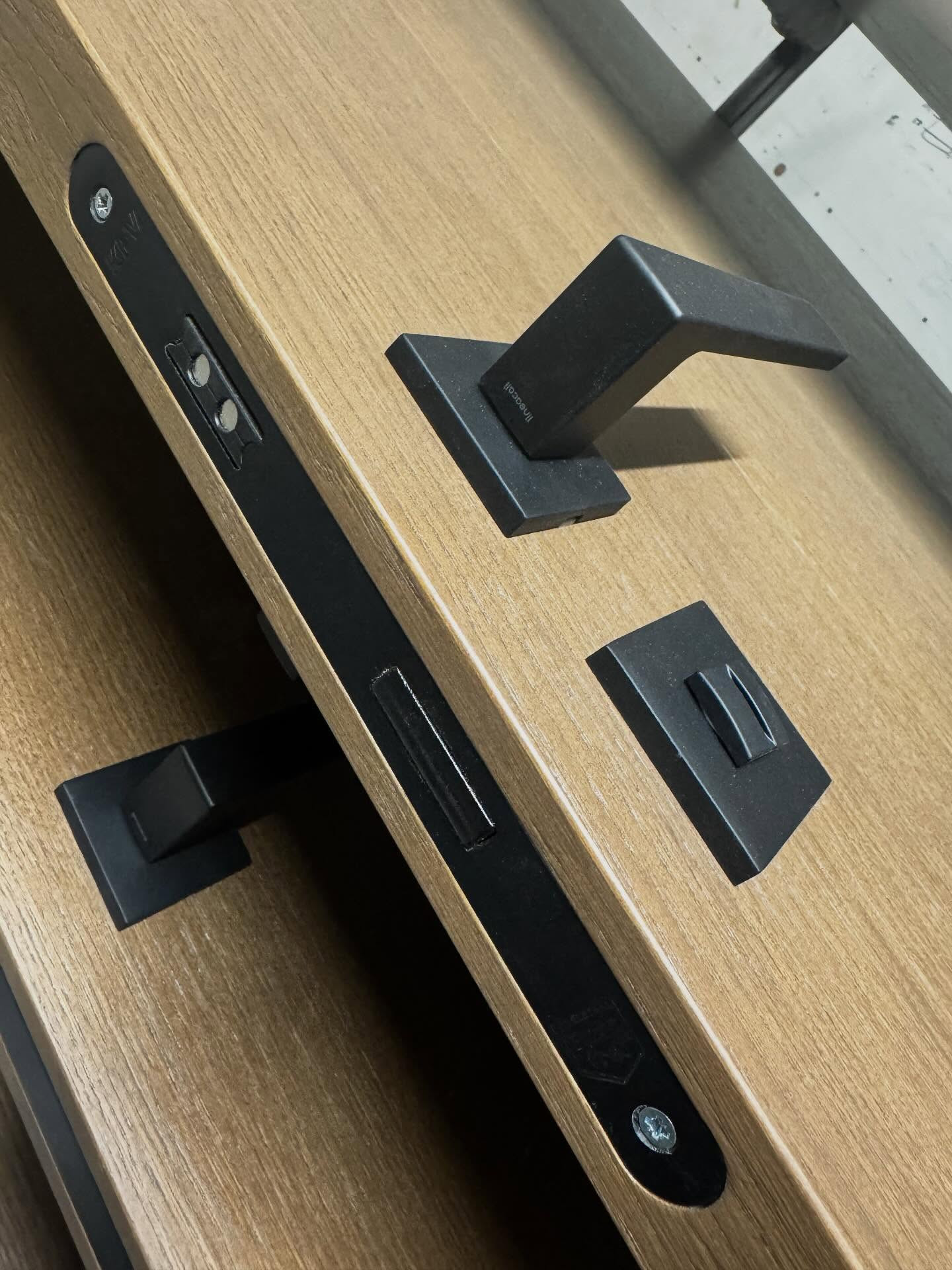 Wooden door with black handle and lock